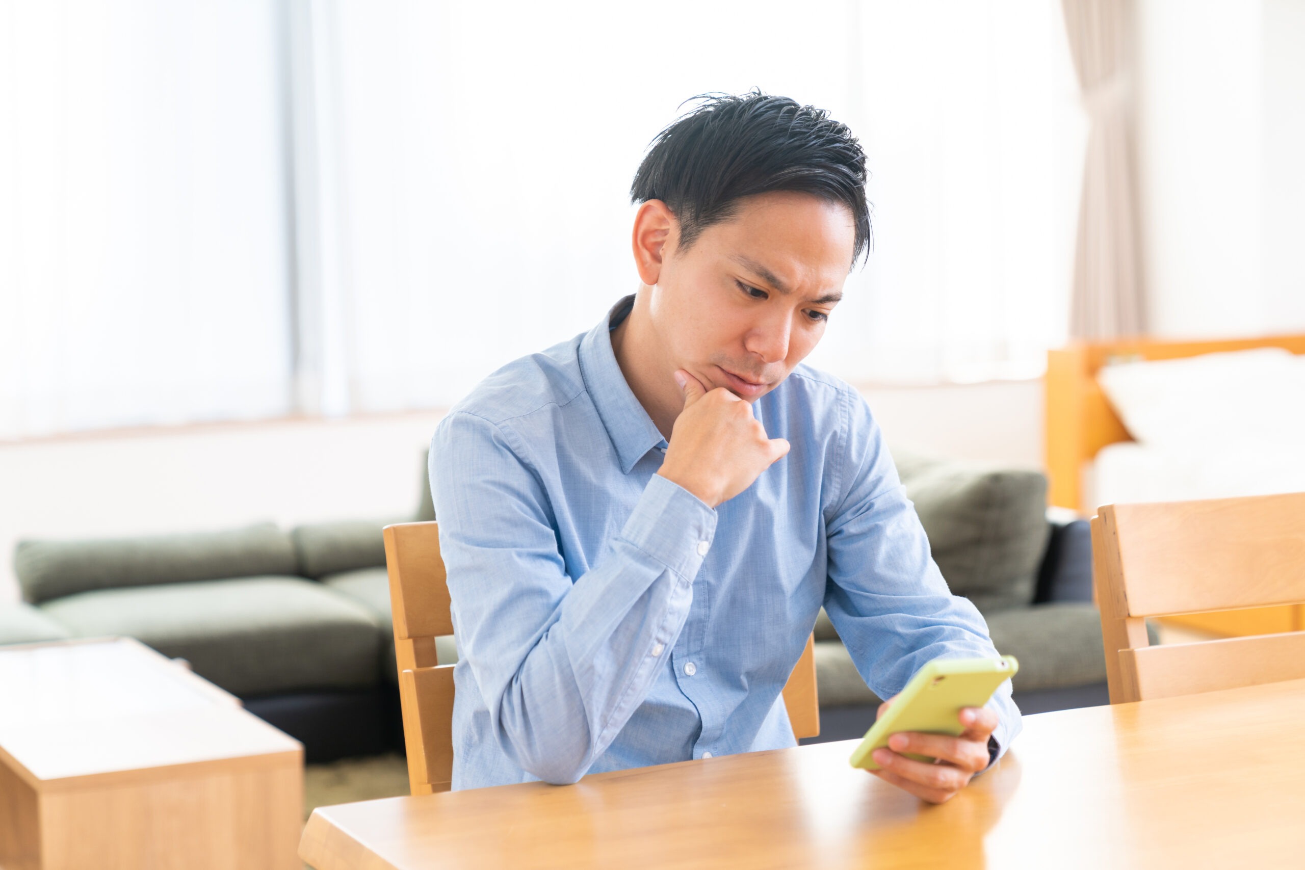 スマホを見て悩む人